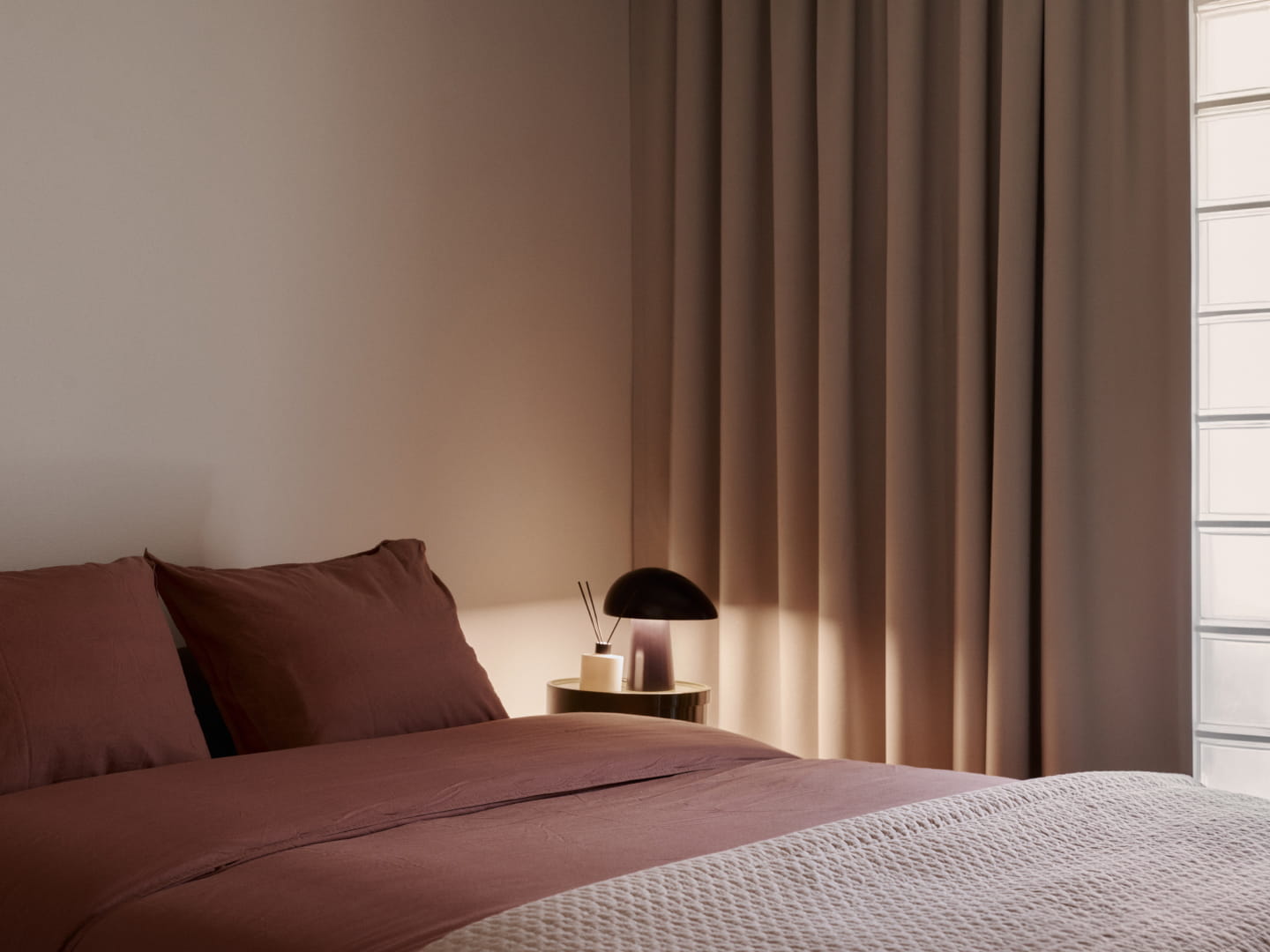 Atmospheric bedroom with a glass tile wall