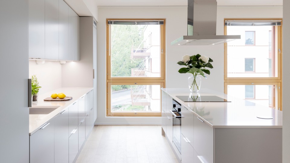 The bright kitchen of the Lehtisaari Terrace apartment with large windows.